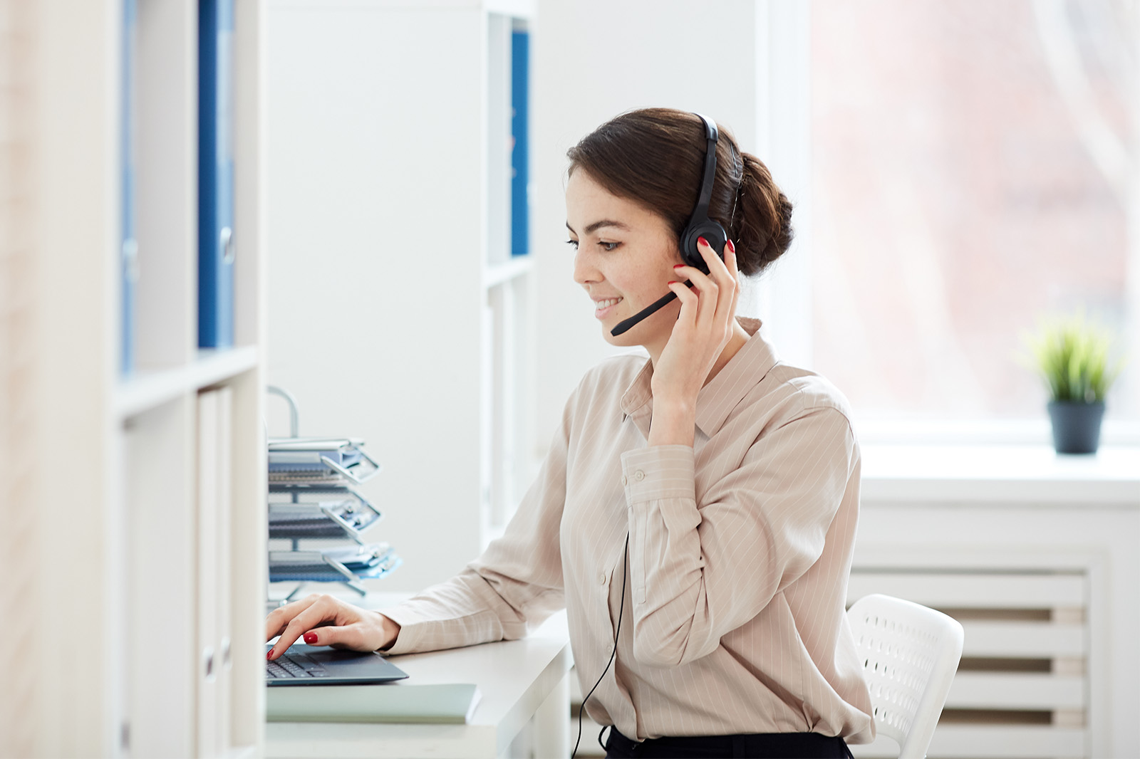 Eine Support Mitarbeiterin hilft einem Kunden telefonisch
